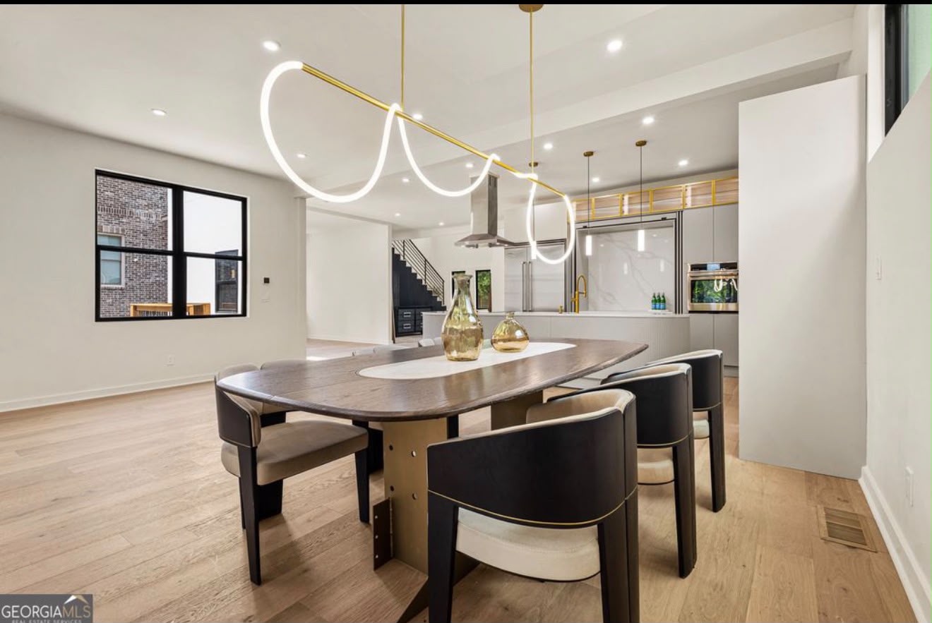 Modern dining room with organic sculptural tube light fixture and open view to a walnut kitchen