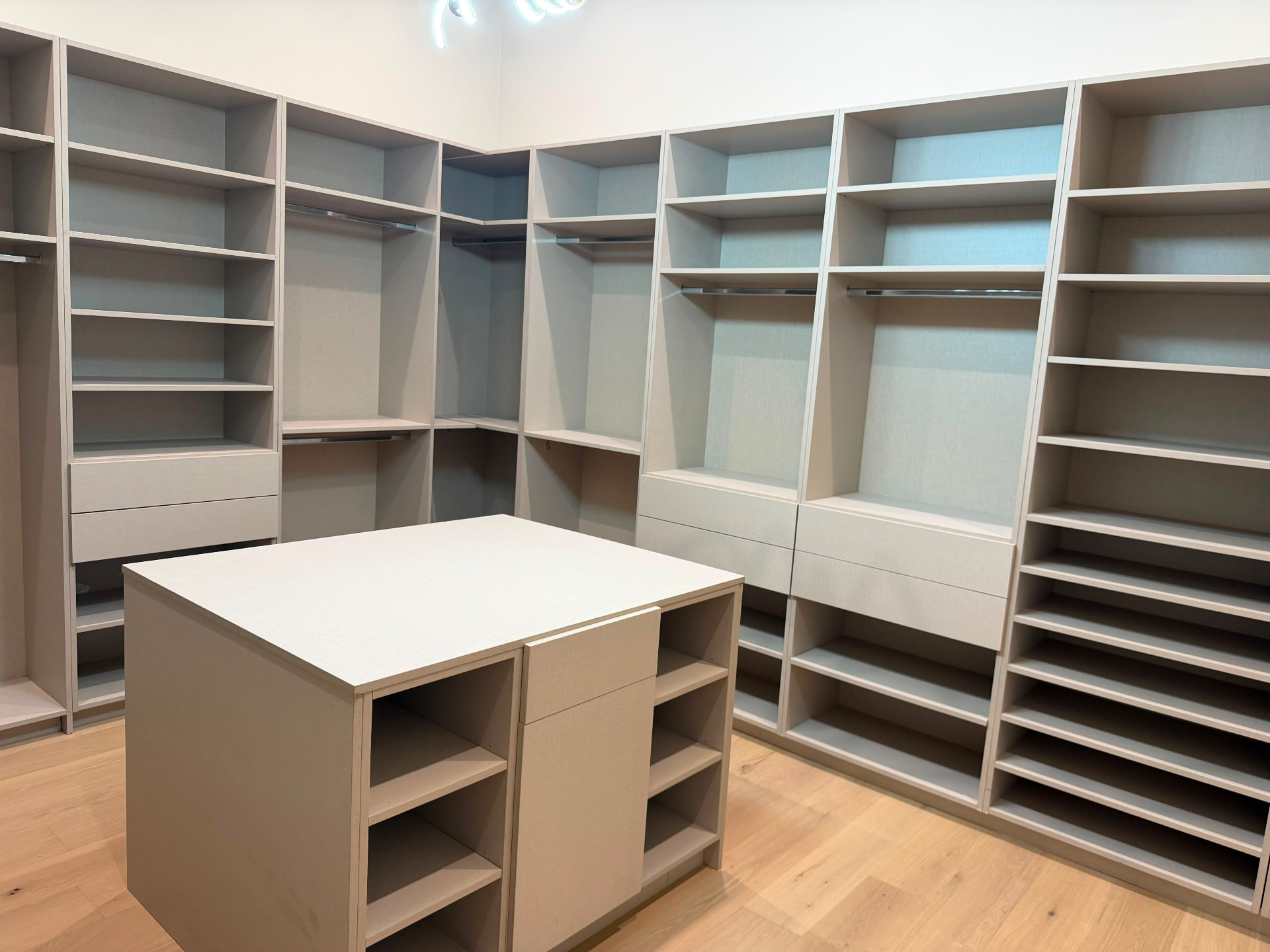 Custom closet shoe wall with angled shelves and drawer storage