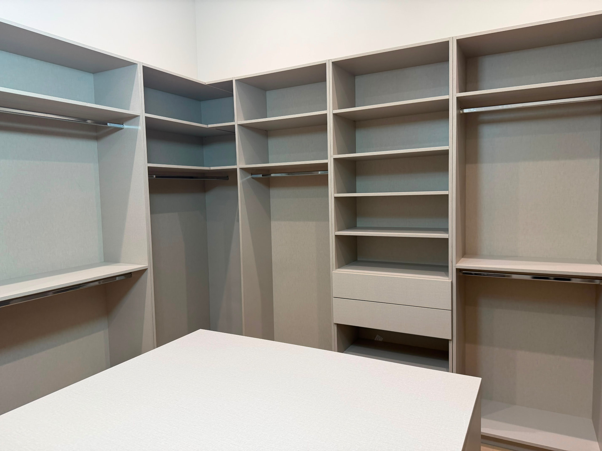 Custom closet corner unit with double hanging rods, open shelving and integrated lighting